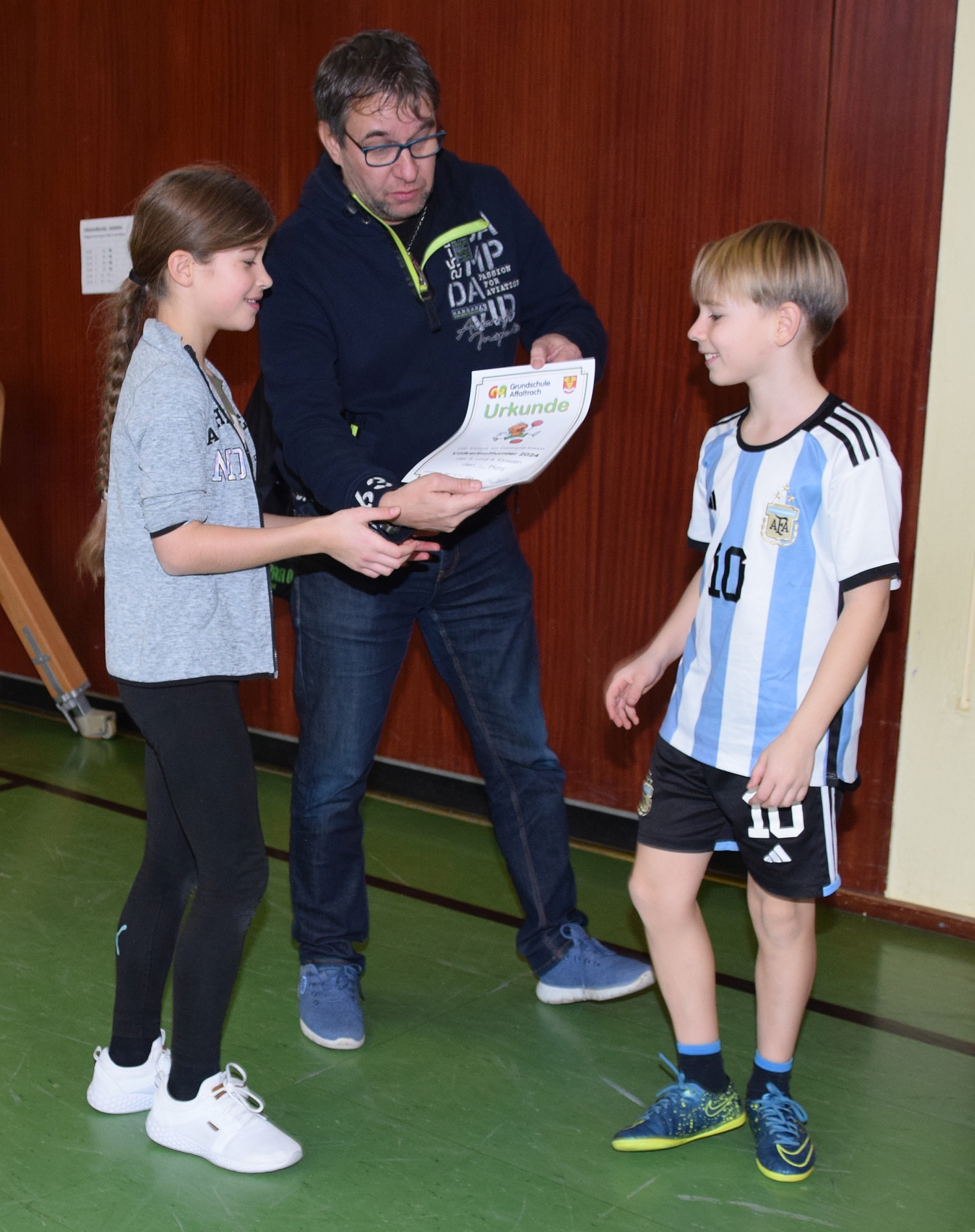 Foto: Rektor Vetter übergibt Urkunde an zwei Kinder